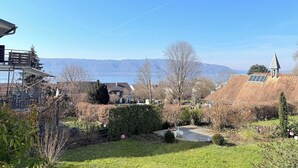 A residential area with a view of distant mountains, a grassy yard, and a building with solar panels. - "Welcome to the MADELEINE vacation apartment: pure relaxation and nature!" (Sipplingen)