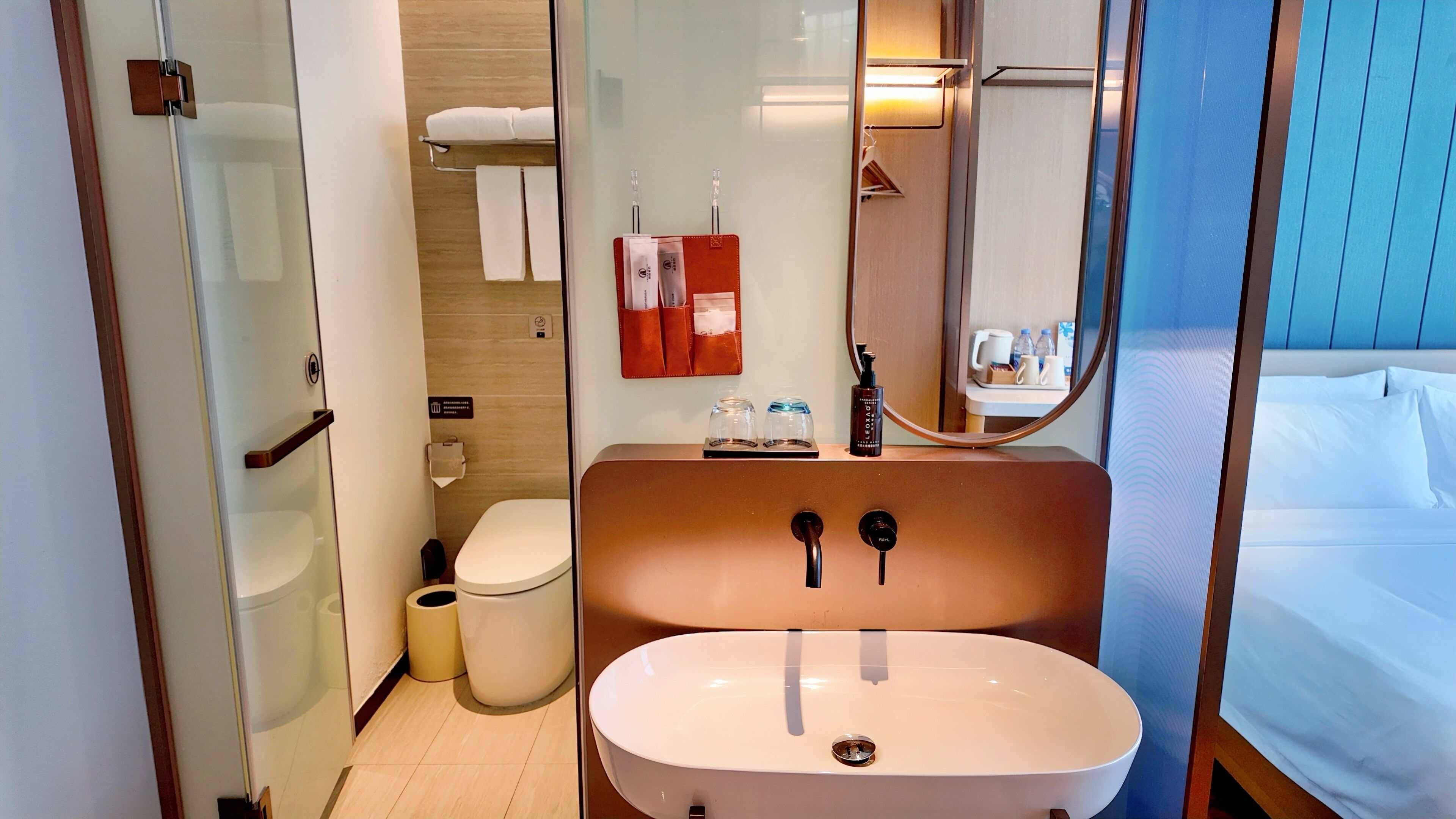 Une salle de bain moderne avec un grand lavabo ovale, des toilettes et un espace douche.