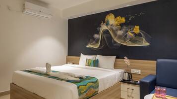 Una habitación de hotel con una cama, mesita de noche y una silla.