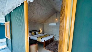 A cozy bedroom with a bed, bedside table, lamp, and a small rug. - Roop Garh Palace (Jamwa Ramgarh)