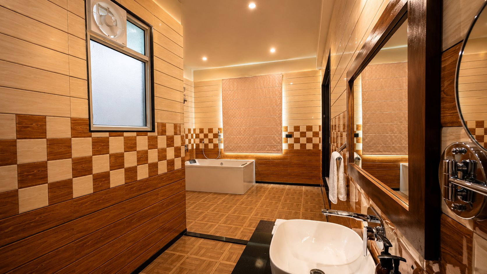 A modern bathroom with a large mirror, a bathtub, and a sink.