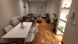 A modern living room with a sofa, TV, and dining area. - 2 bd Renovated Flat at Acropolis (Athens)