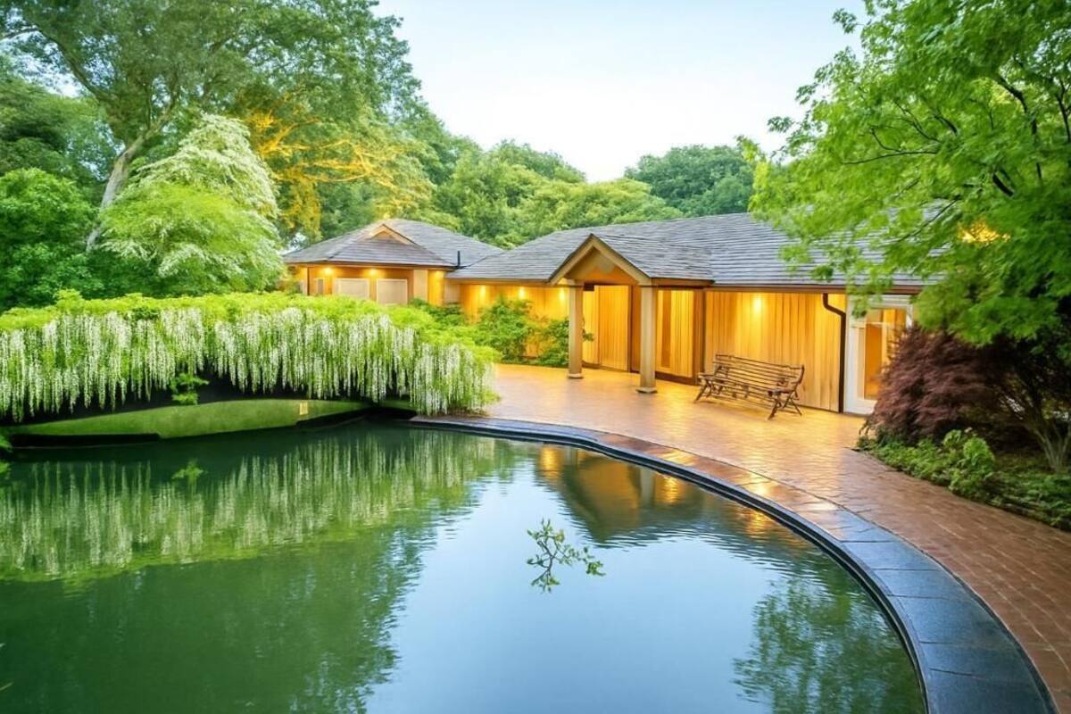 Ein Haus mit Schwimmbad, umgeben von üppigem Grün und Bäumen.