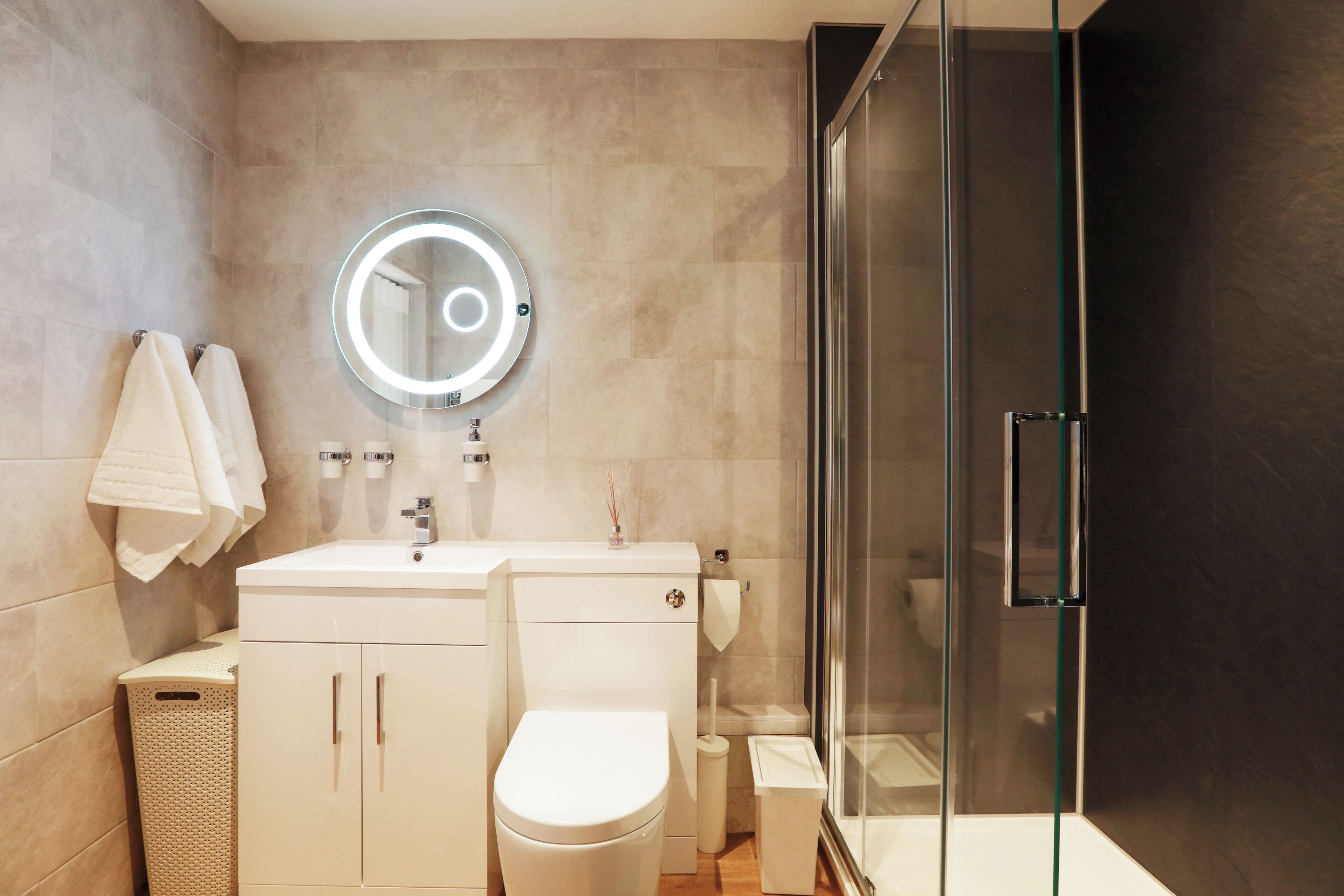 Ein modernes Badezimmer mit Toilette, Waschbecken und Duschkabine aus Glas.
