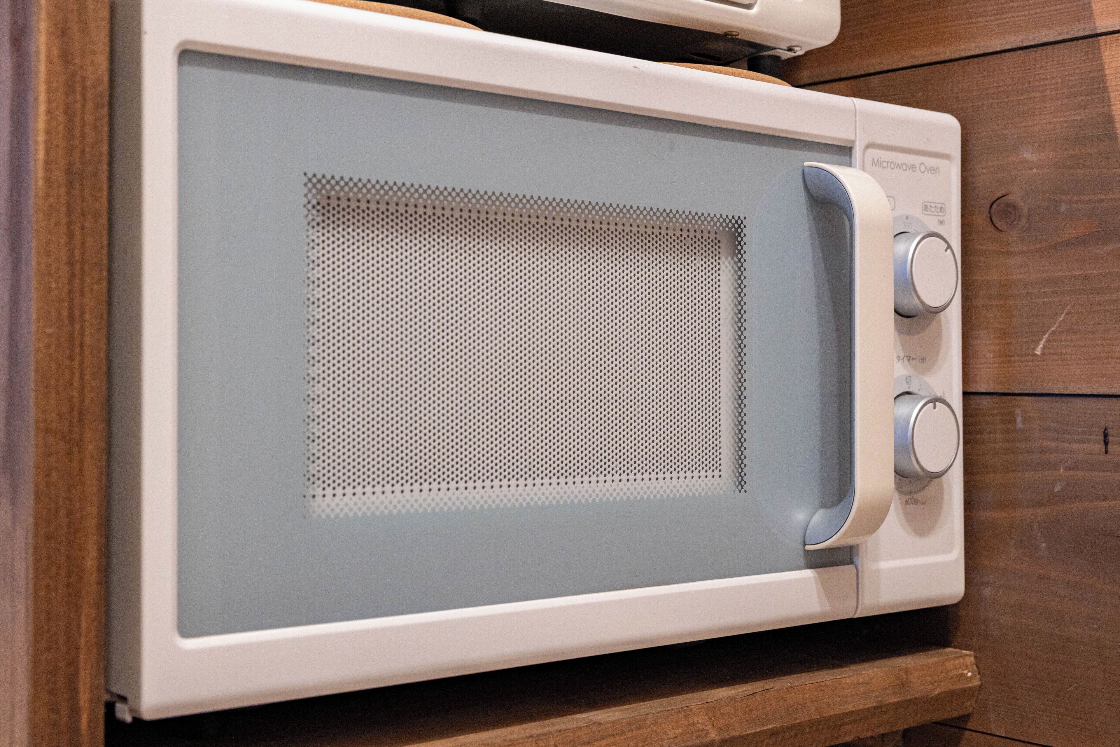 Un horno microondas con panel de control y puerta de malla.