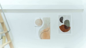 Two abstract artworks on a white wall, a wooden ladder to the left. - Sakura Yoyogi by Tranova (Tokyo)