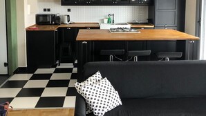 A compact kitchen with black cabinets, a wooden countertop, and a black and white checkered floor. - Luxurious Apartment With big Balcony Best Location (Athens)