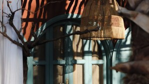 A rustic wooden pergola with a woven hanging light fixture. - Maison Chaliya guesthouse  (Tamazouzte)