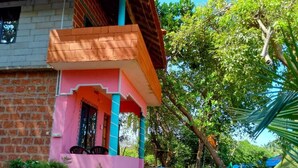 Um edifício de dois andares com fachada rosa e varanda.