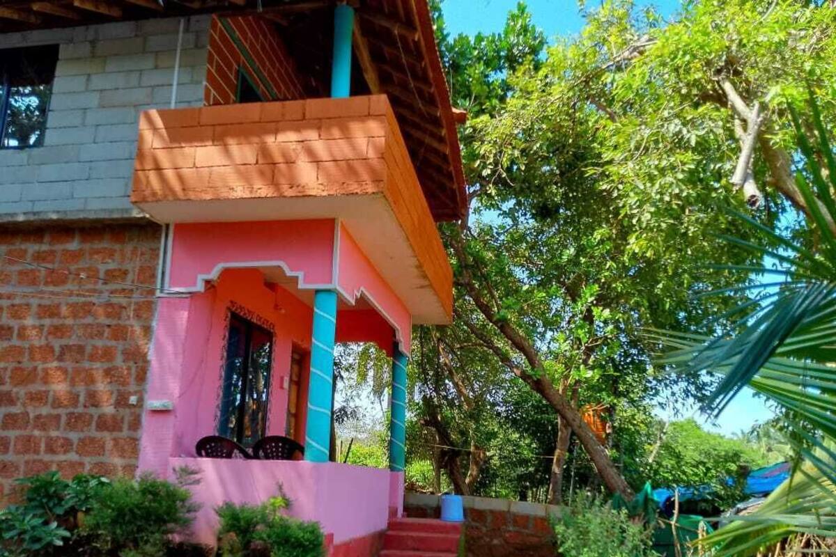 A two-story building with a pink facade and a balcony.