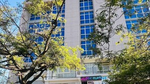 Um hotel com vários andares, grandes janelas e uma placa com a inscrição "BUUTI INTERNATIONAL HOTEL".