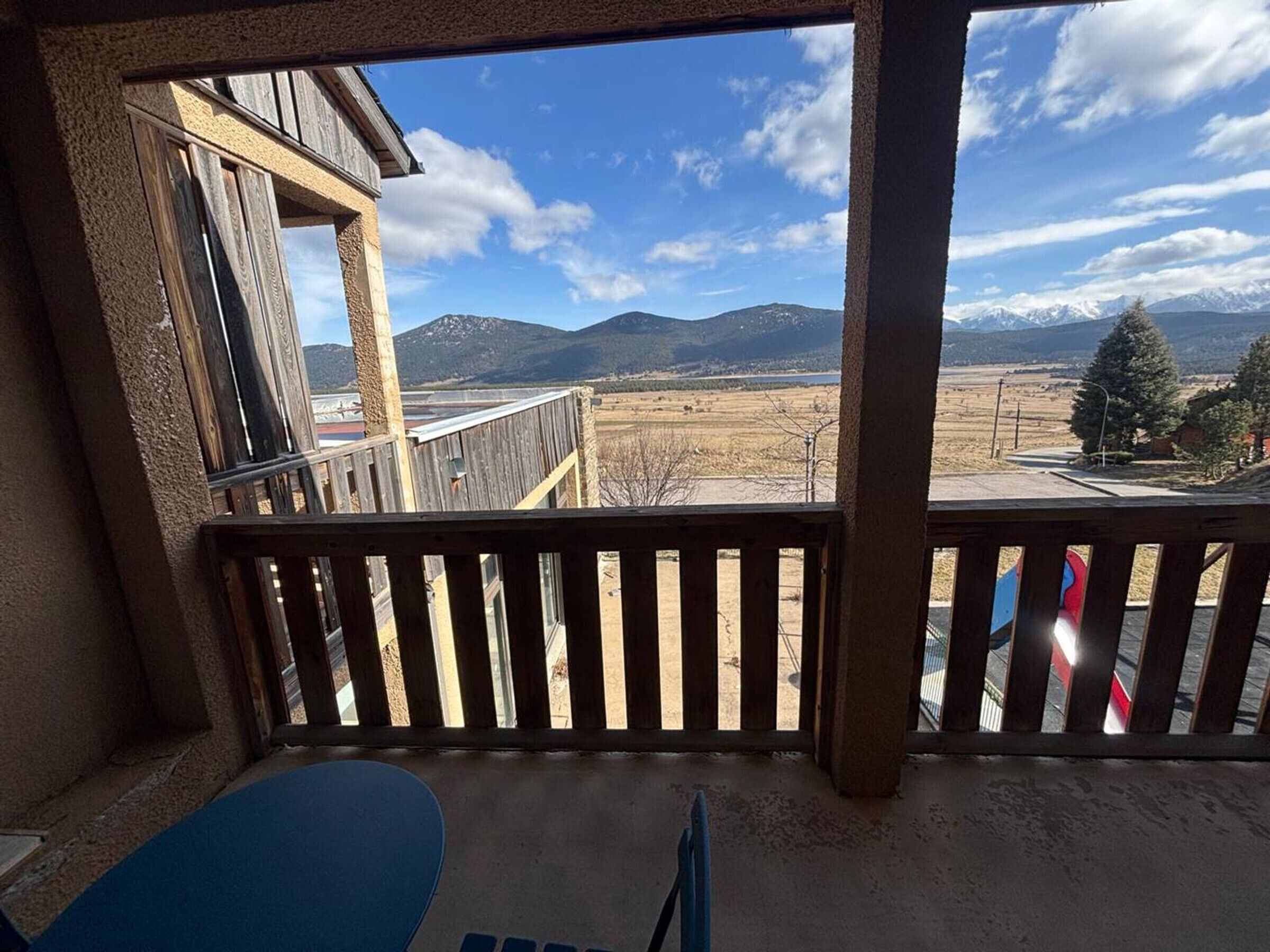 A balcony with a view of mountains and a clear sky.