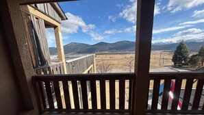 A balcony with a view of mountains and a clear sky.