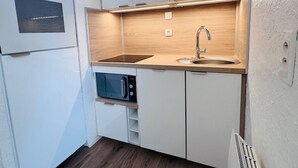 A compact kitchen with a built-in oven, microwave, and sink. - Perfect studio for 4, ski-in/ski-out with large terrace (Les Deux Alpes)