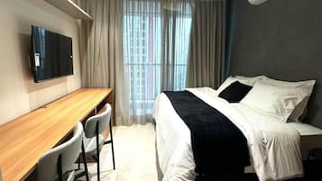 Deluxe Studio Suite, Balcony, Pool View | Desk, laptop workspace, blackout curtains, iron/ironing board