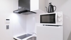 A modern kitchen with a built-in microwave, a coffee maker, and a stainless steel sink. - RIZOTIA HAKUSAN by Tranova (Tokyo)