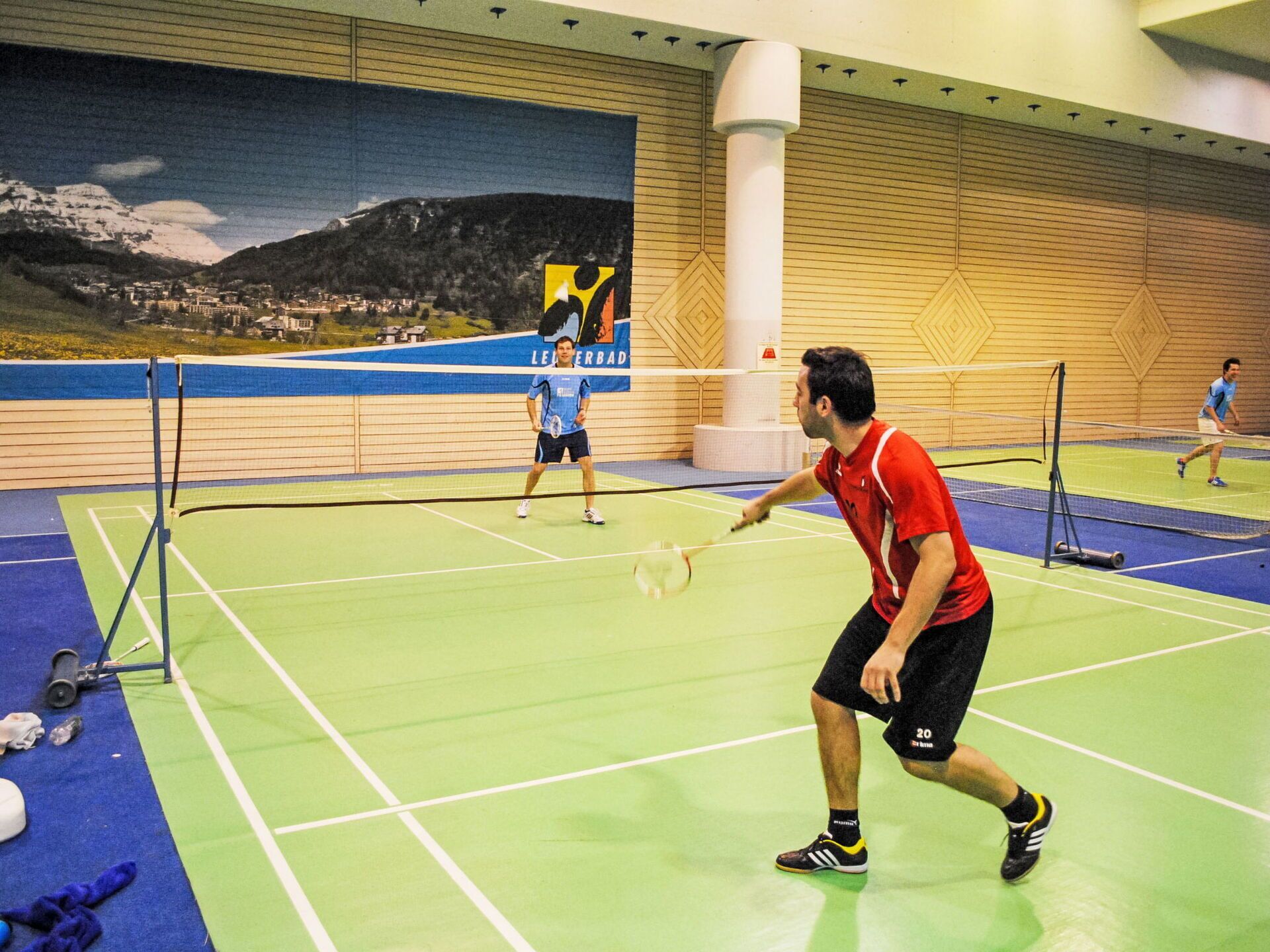 Een binnenshuis badmintonbaan met een net, navelsdoekjes en rackets.