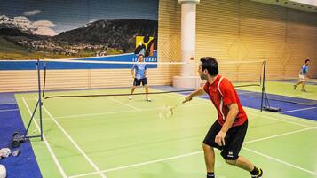 Een binnenshuis badmintonbaan met een net, navelsdoekjes en rackets.