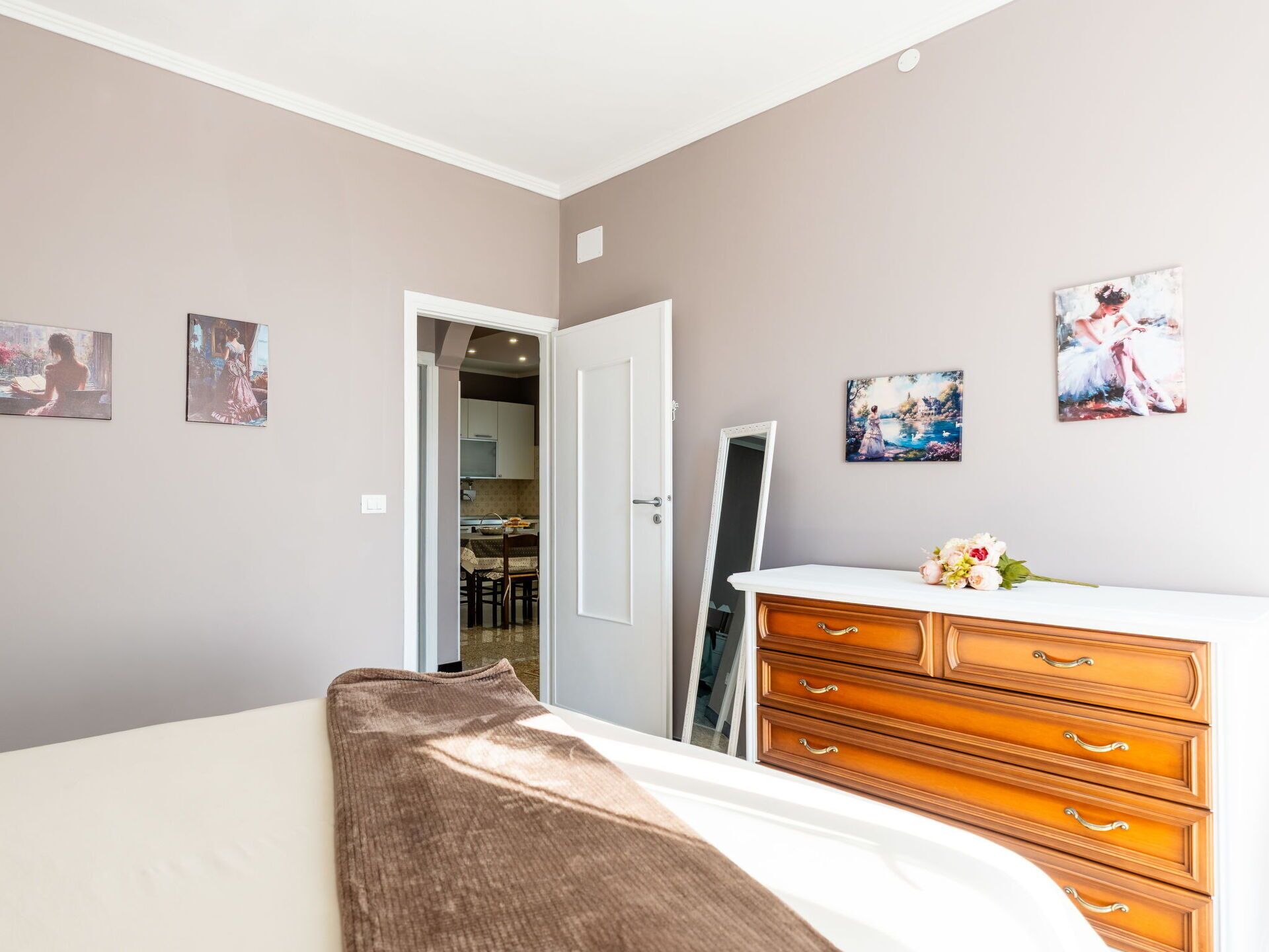 Una camera da letto con un letto, una cassettiera in legno e decorazioni a parete.