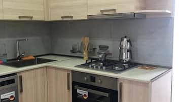 Departamento estándar, vista al patio | Cocina privada | Parrilla de estufa, utensilios de cocina y comedor
