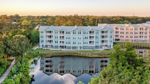 Un hôtel à plusieurs étages offrant une vue sur le front de mer, doté de balcons et d’un bassin décoratif.