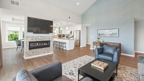 Un salon spacieux avec une cheminée, un coin repas et une cuisine.