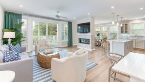 A spacious living room with a fireplace, a dining area, and a kitchen with a large island.