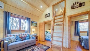 A cozy cabin interior with a sofa, a ladder, and a bed. - Charming 2-bedroom cottage with AC, WiFi in welcoming Waynesville (Waynesville)