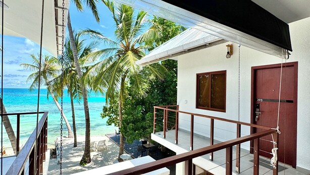 A balcony with a view of the ocean and palm trees. - Comfy Cool Breeze by eMzaz (Dhiffushi)