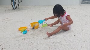 A child playing with sand toys on a concrete surface. - Comfy Cool Breeze by eMzaz (Dhiffushi)