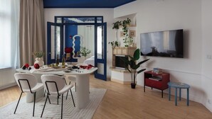 Ein modernes Wohnzimmer mit Essbereich, Kamin und Wand-Fernseher.