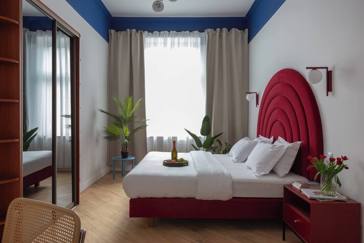 Una camera da letto con un letto, una sedia, un comodino e una pianta in vaso.
