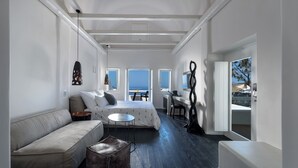 Ein moderner, gut beleuchteter Raum mit Bett, Sofa und Schreibtisch.