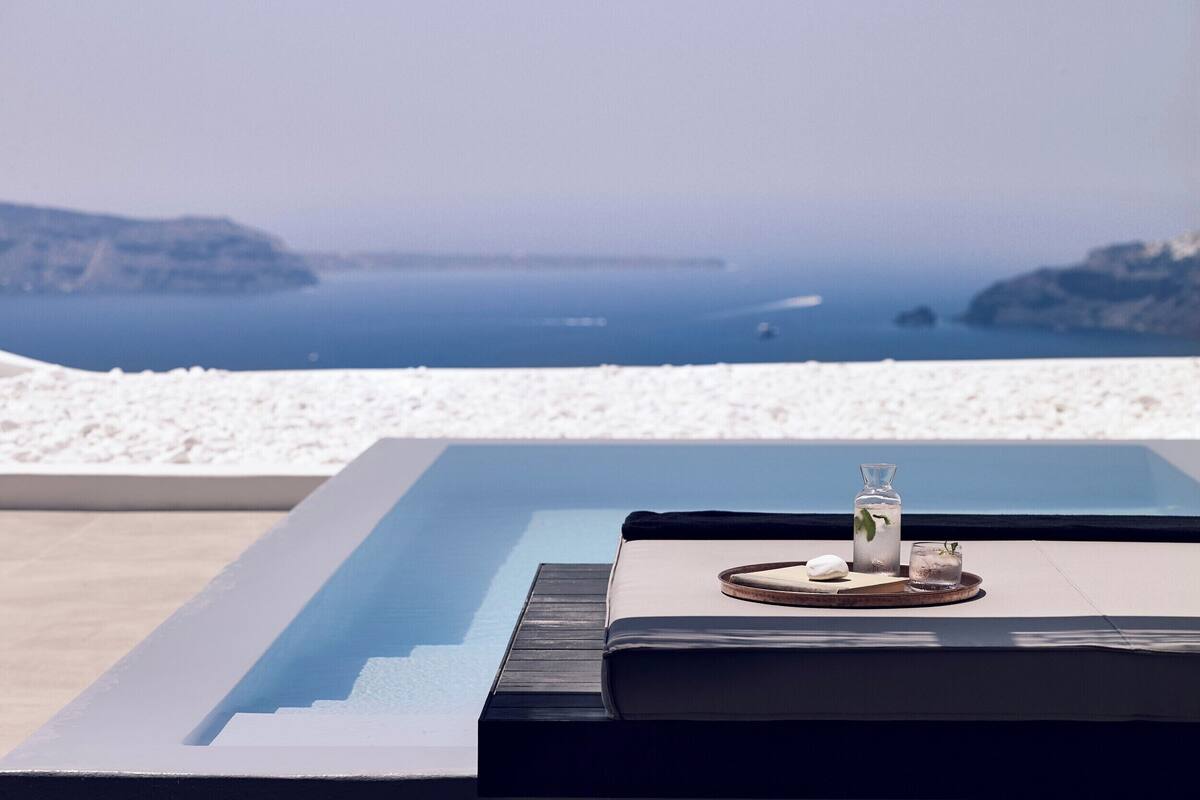 A modern infinity pool with a clear view of the sea and distant islands.