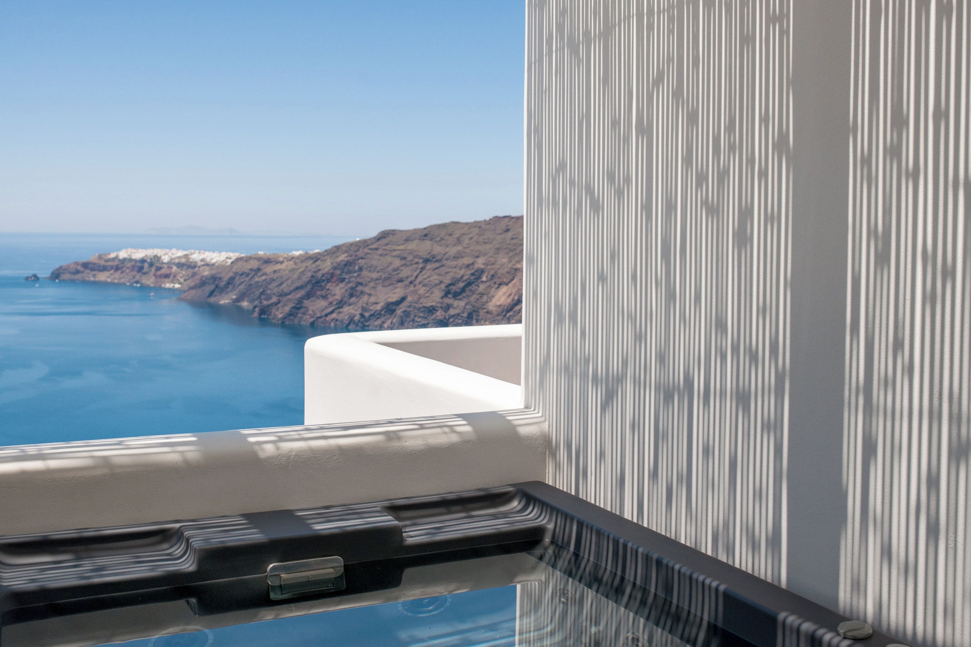 A view from a window overlooking a coastal landscape with a clear sky.