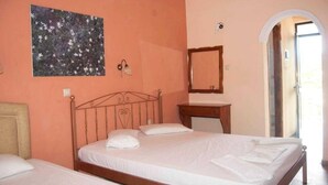 Une chambre à coucher avec un lit, une table de chevet, un miroir et un tableau accroché au mur.