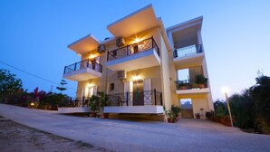 A multi-story building with balconies, air conditioning units, and potted plants. - Ionian View Gem - Parga Garden Nest (Parga)