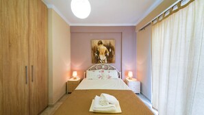 A bedroom with a bed, a nightstand, a wardrobe, and a painting on the wall. - Ionian View Gem - Parga Garden Nest (Parga)