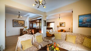 A spacious living room with a sofa set, a dining area, and a kitchen in the background. - Ionian View Haven - Parga Paradise (Parga)
