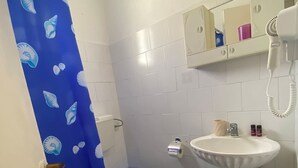 A bathroom with a toilet, sink, and shower curtain.