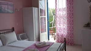A bedroom with a bed, a wardrobe, a desk, and a window with curtains.
