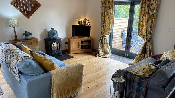 A cozy living room with a sofa, a television, and a wooden cabinet.