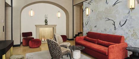 A modern living room with a red sofa, a leopard print chair, and a fireplace.