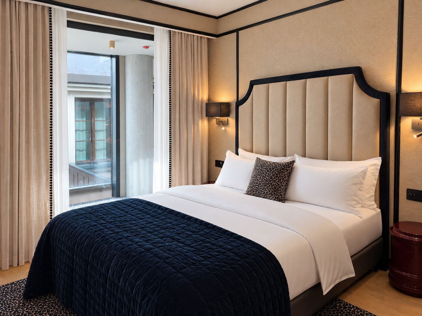 Habitación de hotel con una cama grande, vistas al exterior y un diseño moderno.