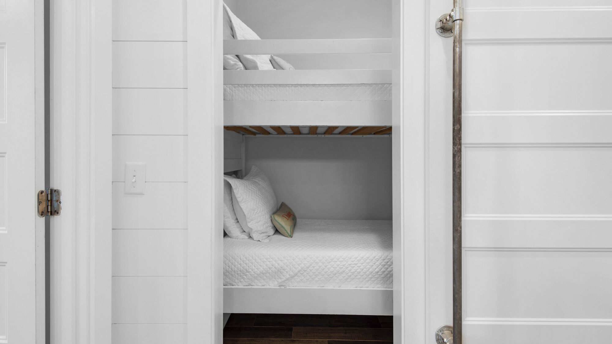 A white room with a bunk bed and a door.