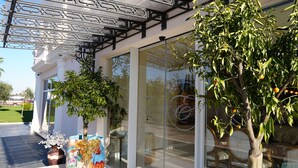 A building with a glass facade, outdoor seating area, and decorative metalwork. - Hotel Eiffel (Kashar)
