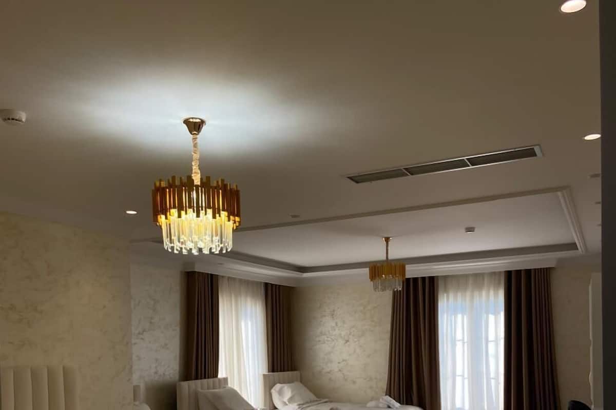Ein Hotelzimmer mit zwei Betten, einer Kandelaber und einem Schreibtisch.