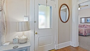 A bedroom with a bed, a bedside table, a lamp, and a mirror. - Indy Stadium Villas 702 (Indianapolis)