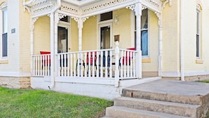 A two-story building with a white porch and a stone staircase leading to the entrance. - Indy Stadium Villas 702 (Indianapolis)