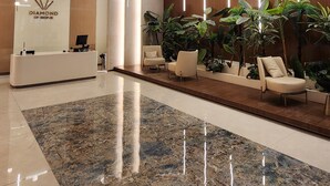 A modern reception area with a marble floor, a reception desk, and several seating areas. - Diamond Residences 2bd 2bth 11th fl. Lux Apt w/ Free Parking (Skopje)